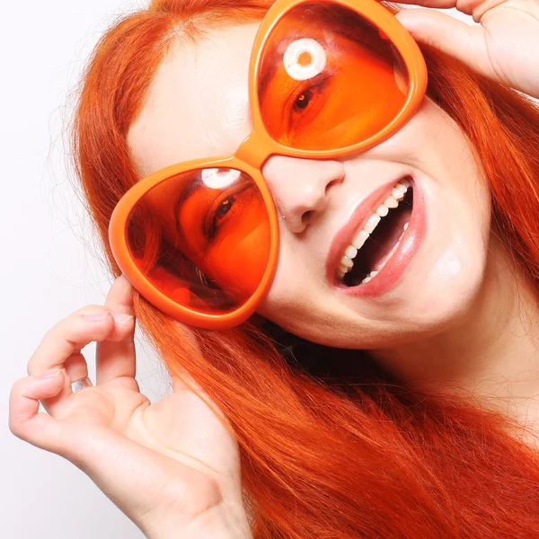 Смешная рыжая женщина в больших оранжевых очках — стоковое фото