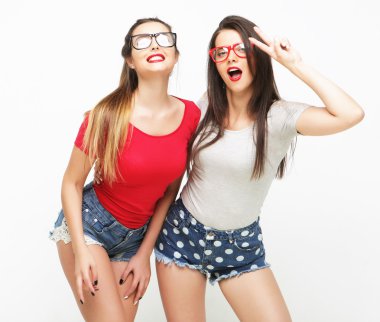 İki genç kız arkadaş birlikte durup eğleniyorlar..