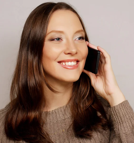 Woman using a mobile phone isolated on a white background — Stock Photo, Image