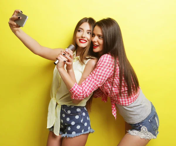 Dos chicas hipster belleza con un micrófono tomar selfi —  Fotos de Stock