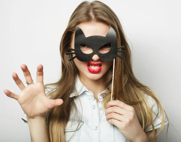 Jeune femme ludique tenant un masque de fête — Photo