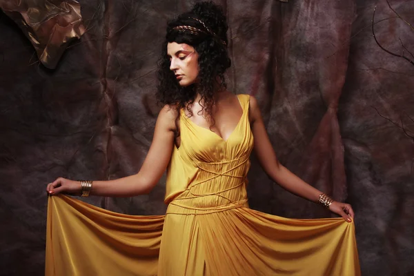 Brunette woman wearing yellow evening dress — Stock Photo, Image