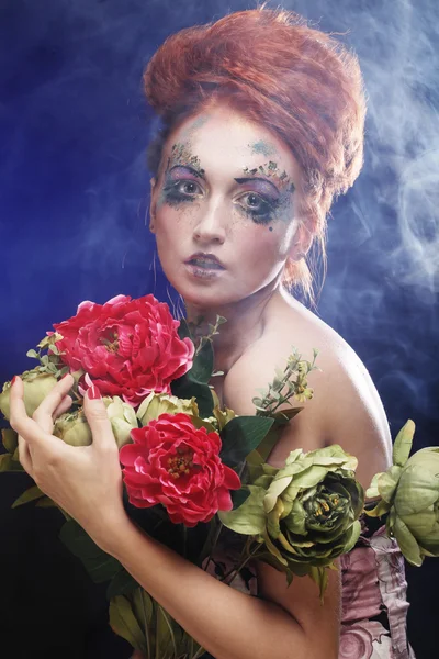 Mooie redhair vrouw bedrijf bloemen — Stockfoto