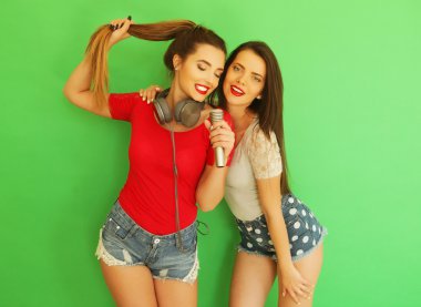 İki genç kız arkadaş birlikte durup eğleniyorlar..