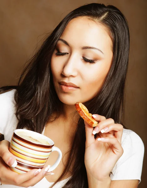 Asiatin mit Kaffee und Keksen. — Stockfoto