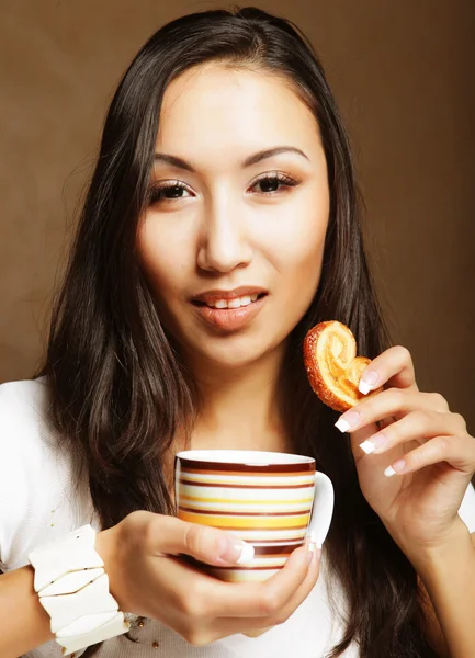 Asiatin mit Kaffee und Keksen. — Stockfoto