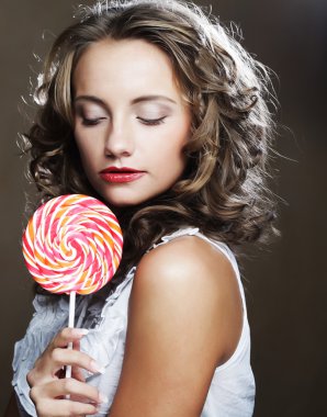bir lolipop onun elinde olan kıvırcık kız
