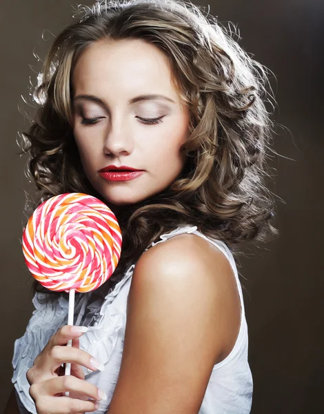 Curly  girl with a lollipop in her hand — Stock Photo, Image