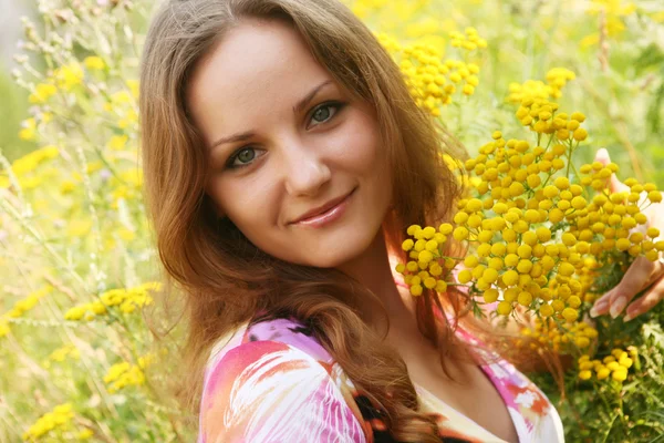 Junge Frau und wilde Blumen. — Stockfoto