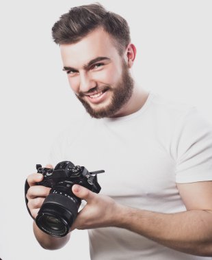 Genç sakallı fotoğrafçı dijital kamerayla fotoğraf çekiyor..