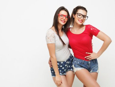 İki genç kız arkadaş birlikte durup eğleniyorlar..