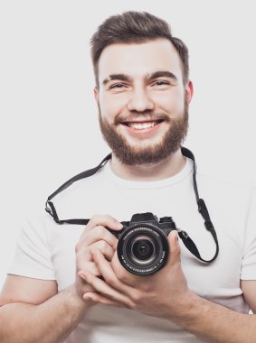 Genç sakallı fotoğrafçı dijital kamerayla fotoğraf çekiyor..