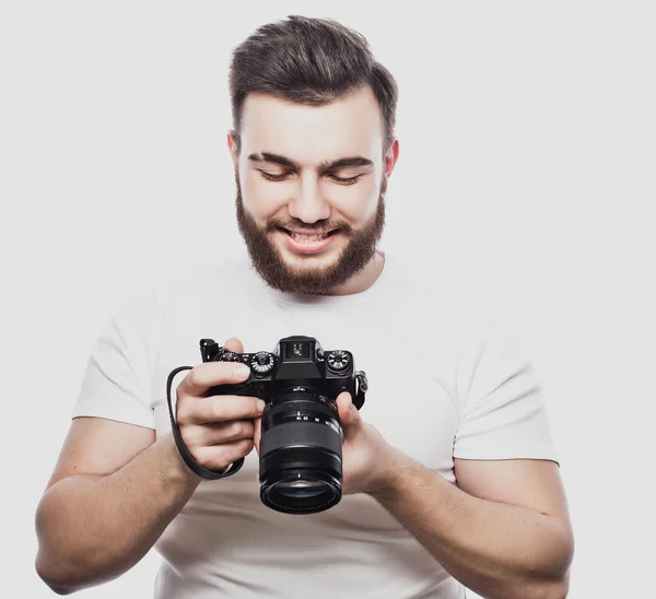 Joven fotógrafo barbudo tomando fotos con cámara digital . —  Fotos de Stock