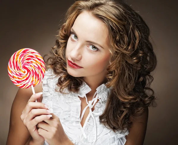 Curly  girl with a lollipop in her hand — Stock Photo, Image