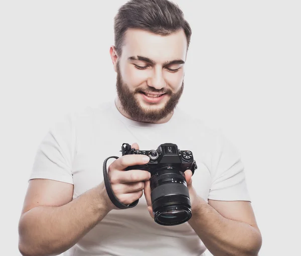 Joven fotógrafo barbudo tomando fotos con cámara digital . —  Fotos de Stock