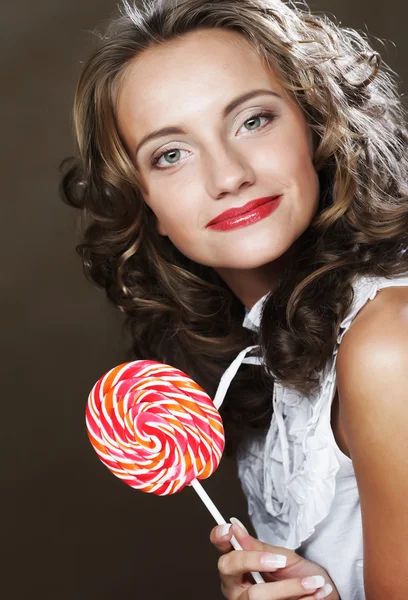 Curly  girl with a lollipop in her hand — Stock Photo, Image