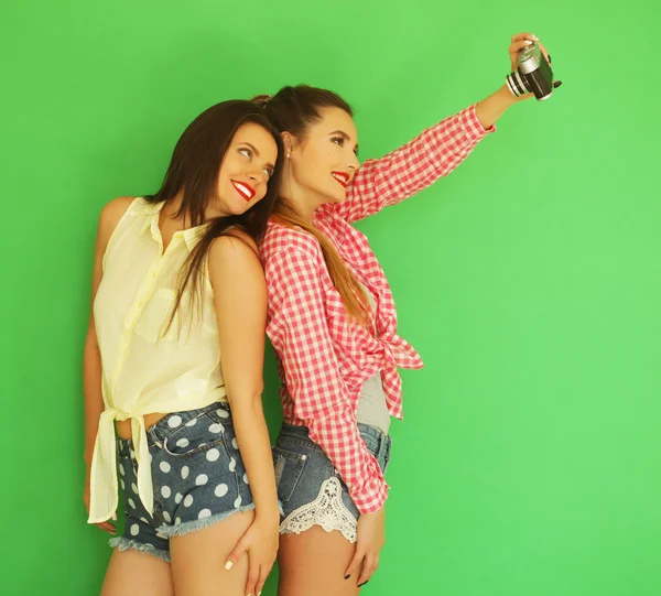 Melhores amigos hipster meninas de pé junto com câmera de fotos — Fotografia de Stock