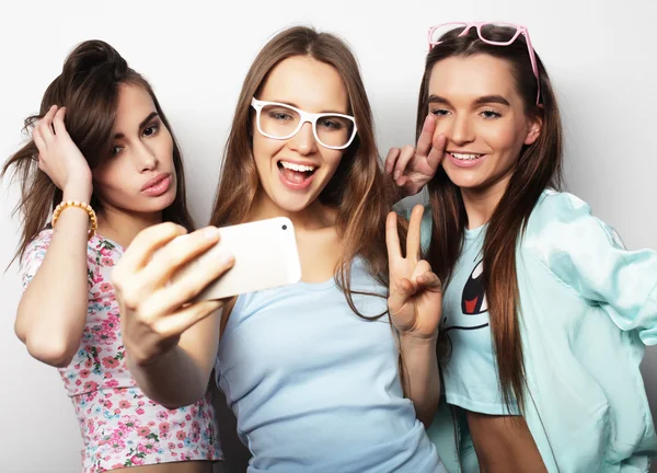 Tres chicas adolescentes felices con teléfono inteligente tomando selfie —  Fotos de Stock