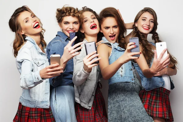 Groep van jonge vrouwen kijken naar hun smartphones — Stockfoto