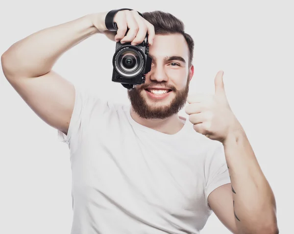 Joven fotógrafo barbudo tomando fotos con cámara digital . —  Fotos de Stock