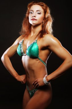 Siyah arka planda bikinili sarışın kadın.