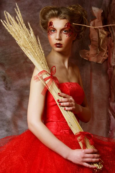Mulher de vestido vermelho. Penteado fantástico e maquiagem . — Fotografia de Stock