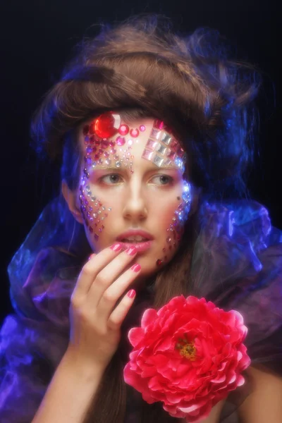 Mujer joven con rostro artístico sosteniendo gran flor roja — Foto de Stock