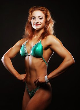 Siyah arka planda bikinili sarışın kadın.