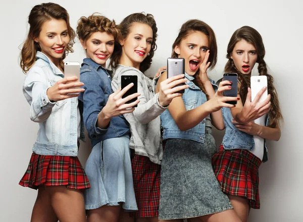 Grupa młodych kobiet, patrząc na ich smartfonach — Zdjęcie stockowe