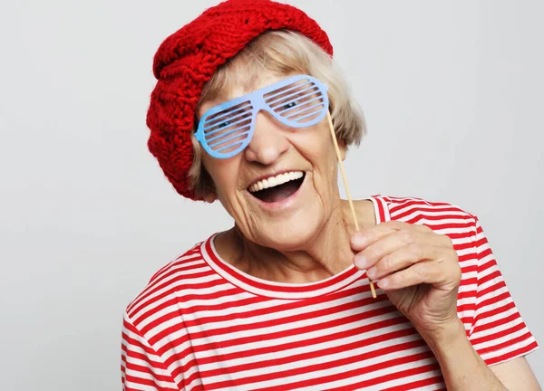 Estilo de vida, emoción y concepto de la gente: abuela divertida con gafas falsas, risas y listo para la fiesta — Foto de Stock