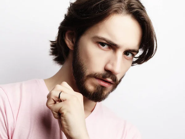 Young handsome male with beard, mustache and trendy hairdo, wears casual pink t-shirt — Stock Photo, Image