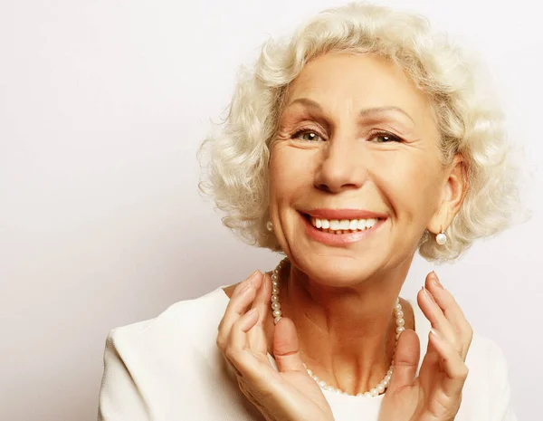 Estilo de vida, la emoción y el concepto de la gente: gris pelo viejo agradable hermosa mujer riendo. Aislado sobre fondo vwhite —  Fotos de Stock