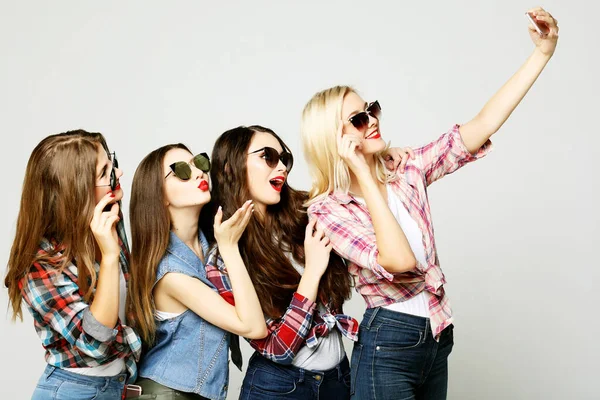 Чотири щасливі дівчата-підлітки зі смартфоном, що приймає селфі — стокове фото
