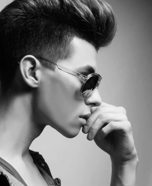 El hermoso joven con gafas de sol sobre un fondo blanco. Concepto de moda. —  Fotos de Stock