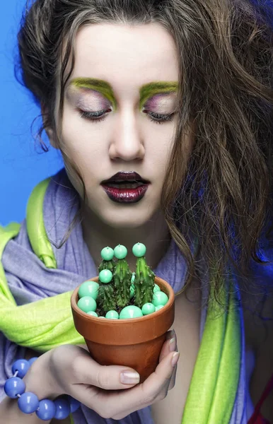 Hermosa mujer joven con maquillaje brillante sobre fondo azul — Foto de Stock