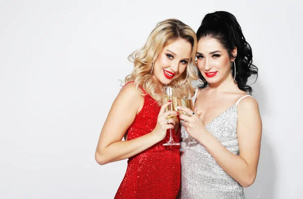 Schöne junge Frauen in Abendkleidern trinken Champagner und feiern das neue Jahr. — Stockfoto