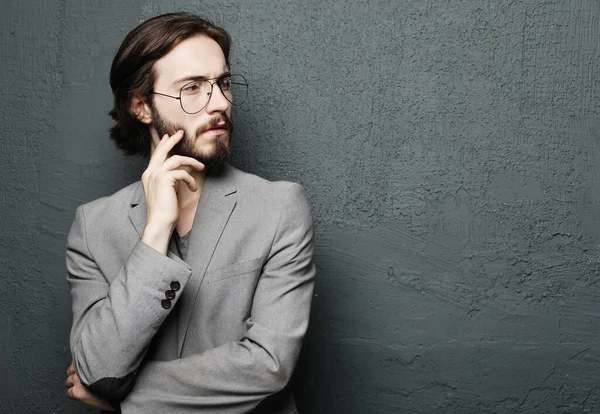 Junger schöner Mann posiert auf grauem Wandhintergrund — Stockfoto