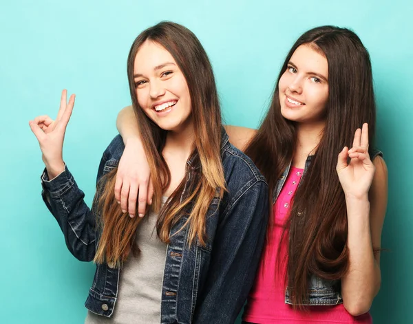 Two young teenager friends standing together and having fun. Showing signs with hands. Looking at camera — Stock Photo, Image