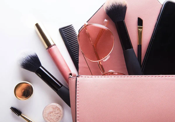 Lapos laikus rózsaszín bőr nő táska nyitott kozmetikumok és okostelefon fehér háttér — Stock Fotó