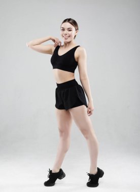 Gri arka planda duran kendine güvenen güzel kadın.