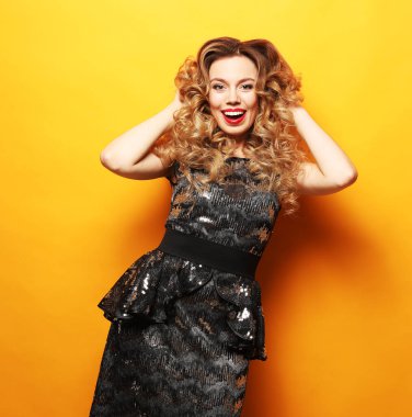 Parlak elbiseli, çarpıcı sarışın bir kadının fotoğrafı. Parti zamanı.