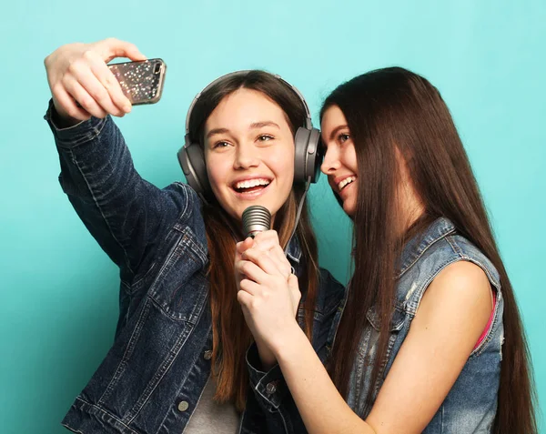 Estilo de vida, felicidade, emocional e conceito de pessoas: adolescentes hipster beleza com um microfone cantando e tirar foto com smartphone — Fotografia de Stock