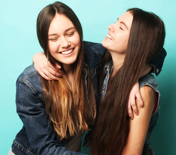 Lifestyle, people, teens and friendship concept - happy smiling pretty teenage girls or friends hugging over blue background — Stock Photo, Image