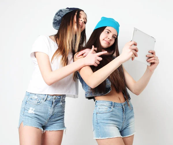 Два друга-подростка, женщина-хипстер, делают селфи с цифровым планшетом — стоковое фото