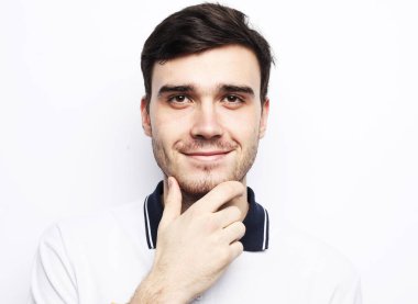 Mutlu adam kameraya bakıyor ve beyaz arka planda gülümsüyor.