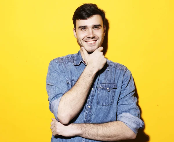 Ung leende man står mot gul bakgrund — Stockfoto