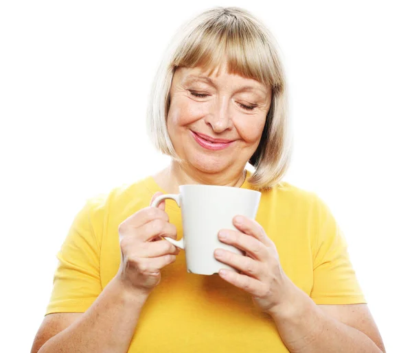 Mulher madura com cabelo curto, ela está desfrutando de café fresco em suas mãos, — Fotografia de Stock