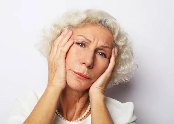 Una anciana frustrada tocando la frente. Preocupado estresado abuela mayor madura que tiene sentimientos dolorosos en la cabeza. —  Fotos de Stock