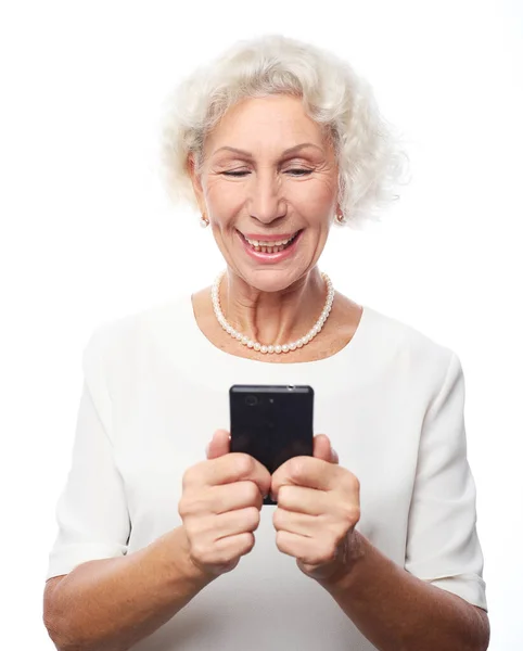 Retrato de velha senhora sorridente de cabelos grisalhos olhando para a tela do telefone celular — Fotografia de Stock