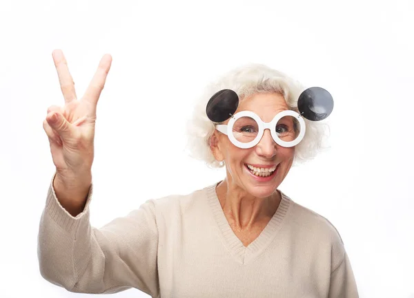 Фото гарного настрою щасливої усміхненої позитивної старої жінки показують v-знак носити великі сонцезахисні окуляри — стокове фото